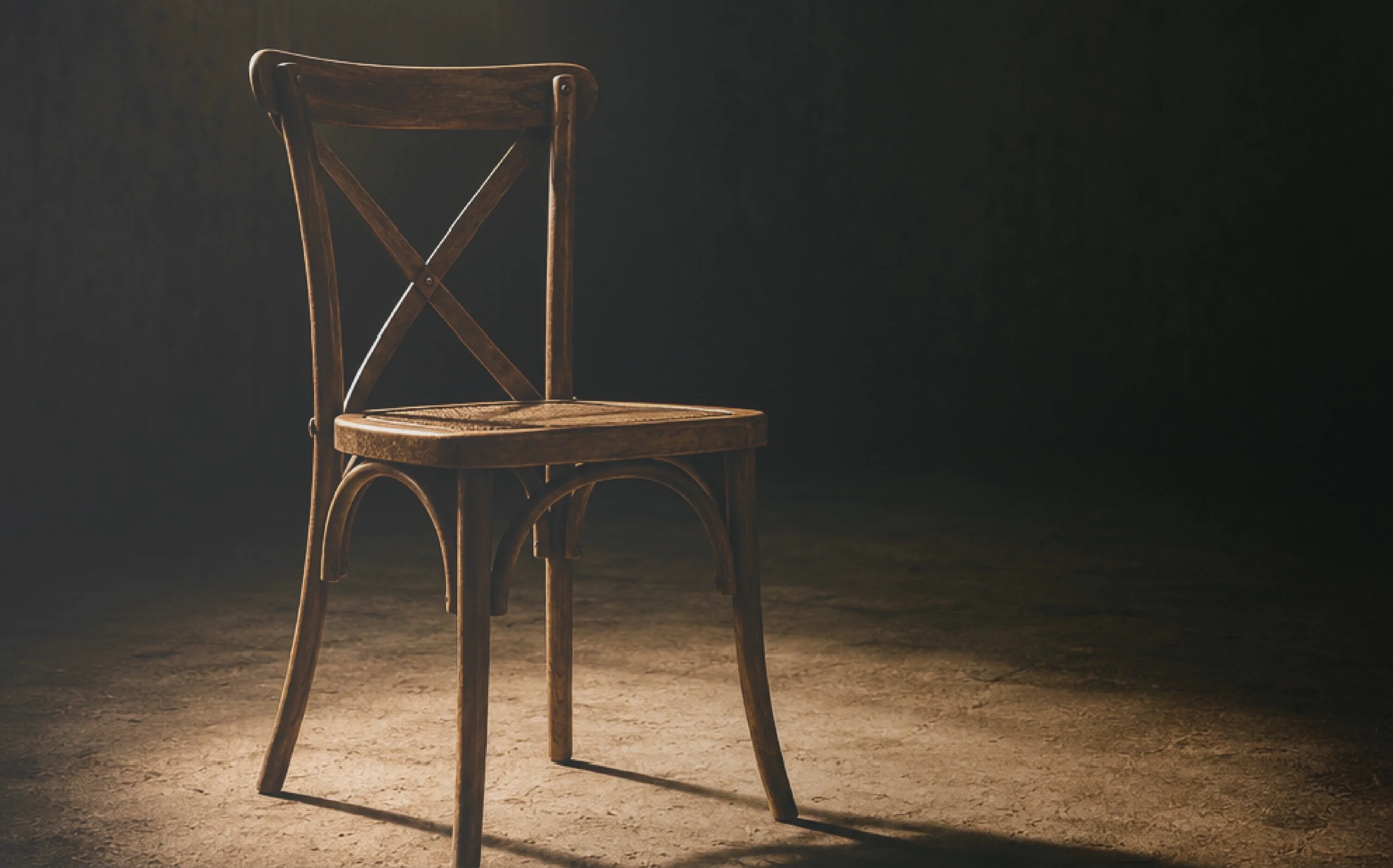 A single wooden chair in a beam of light