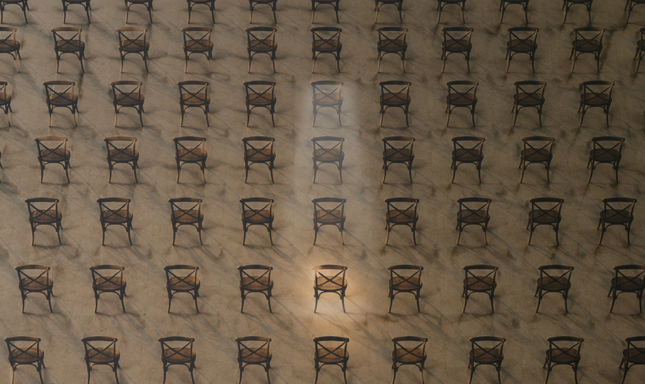 Rows upon rows of empty wooden chairs seen from above